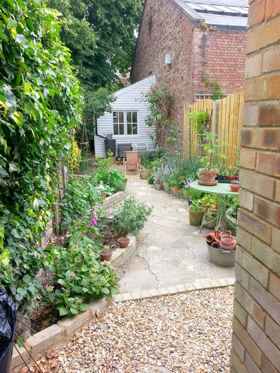 a long and narrow garden clad with stone, with raised garden beds with bold blooms and greenery is a lovely space a long and narrow garden clad with stone, with raised garden beds with bold blooms and greenery is a lovely space