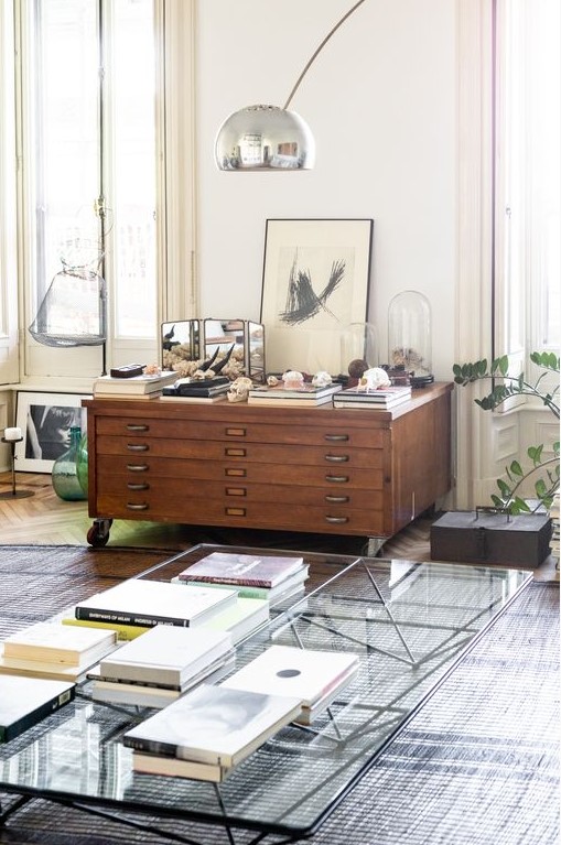 a stained low filing cabinet on casters is a console table in your living room that provides storage and that you can style