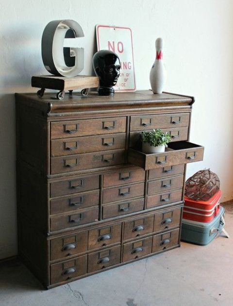 a vintage dark-stained file cabinet used for storage and as a plant stand will be a lovely addition to a vintage, rustic or industrial interior