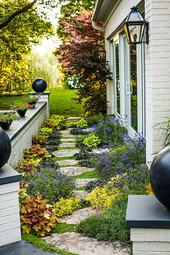 a small narrow garden with a brick fence, bright blooms and plants and a stone pathway is a fresh way to make your outdoors bolder a small narrow garden with a brick fence, bright blooms and plants and a stone pathway is a fresh way to make your outdoors bolder