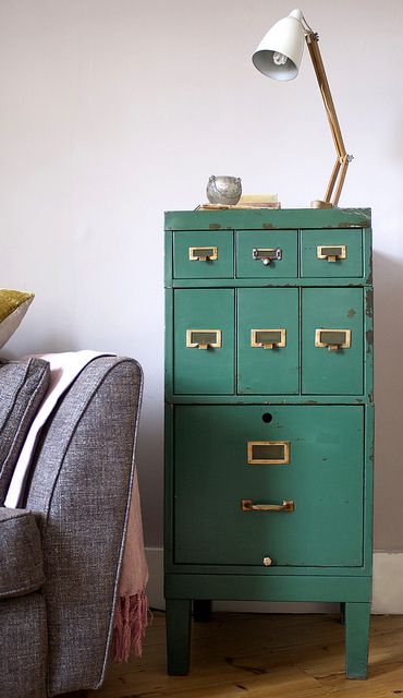an emerald card cabinet with gold knobs is a beautiful vintage touch to your space, it will add both color and a vintage feel