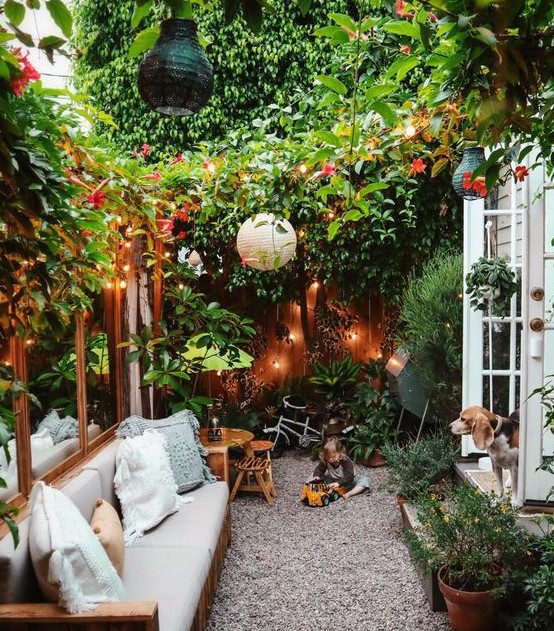 a very cozy small backyard with lots of greenery and blooms, lights, paper lamps and some comfy furniture a very cozy small backyard with lots of greenery and blooms, lights, paper lamps and some comfy furniture