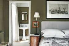 28 an olive green bedroom with a printed upholstered bed and bedding, a black and white artwork, stained furniture