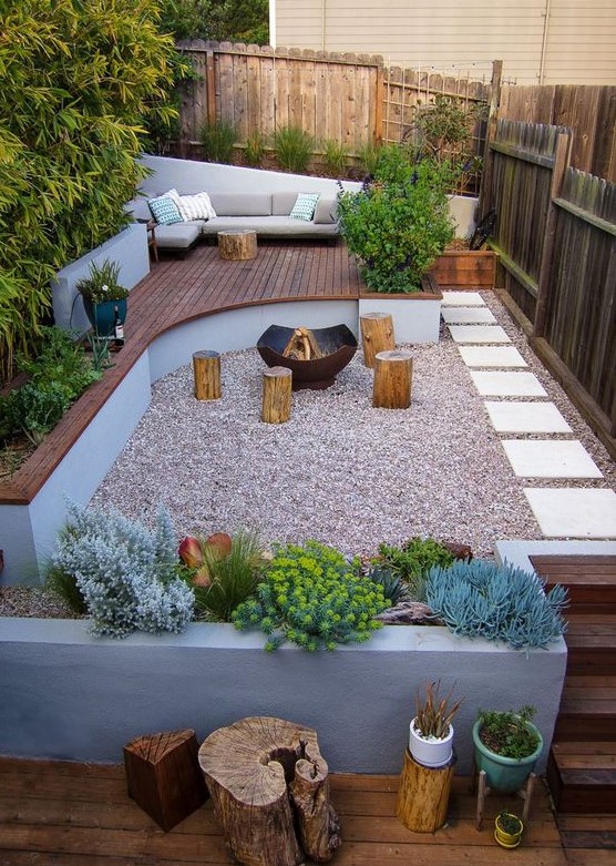 an ultra modern backyard with a wooden deck with furniture, concrete planters, tree stumps and a fire pit an ultra-modern backyard with a wooden deck with furniture, concrete planters, tree stumps and a fire pit