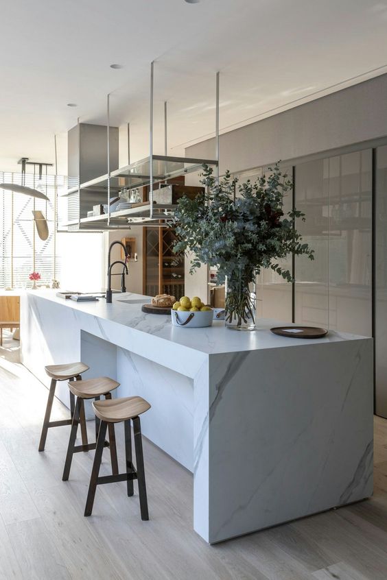 https://www.digsdigs.com/photos/2023/05/38-a-sophisticated-minimalist-kitchen-with-a-sleek-grey-storage-unit-a-white-marble-kitchen-island-a-suspended-shelf.jpg