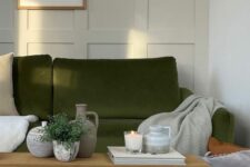 41 a Scandinavian living room with creamy paneling, an olive green sofa and neutral textiles, a wooden bench with decor