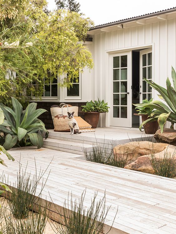 a lovely outdoor space with a whitewashed wooden deck, potted plants and some rocks is awesome a lovely outdoor space with a whitewashed wooden deck, potted plants and some rocks is awesome