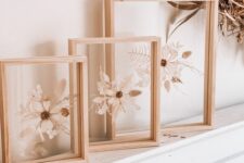 a beautiful home decoration of dried white blooms and leaves in light-stained frames is a cool idea for a mantel