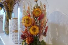 a bold dried flower dome with moss, rust and burgundy blooms, neutral and red bunny tails, grasses for summer mantel decor