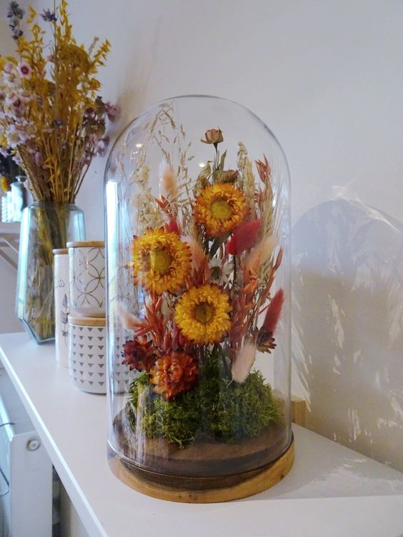 a bold dried flower dome with moss, rust and burgundy blooms, neutral and red bunny tails, grasses for summer mantel decor