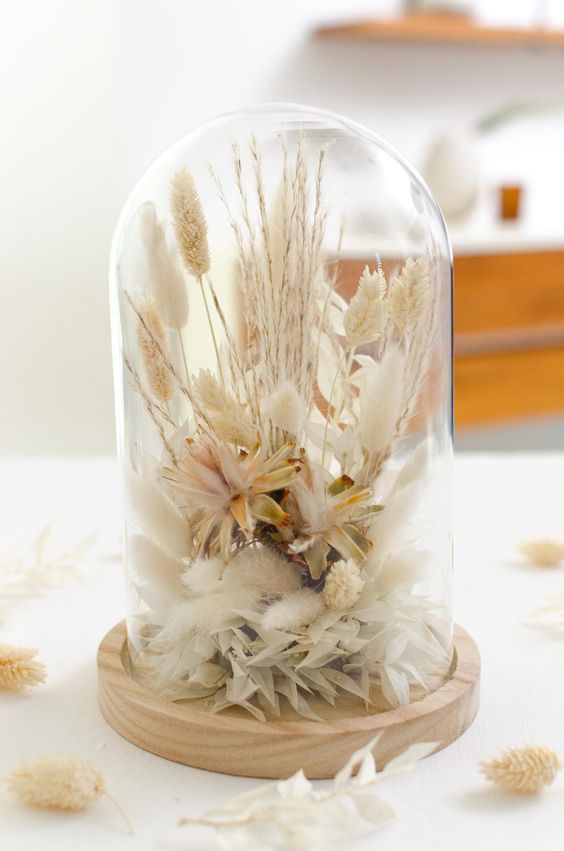 a cloche dried flower arrangement wiht dried neutral blooms, lots of herbs and leaves and some wheat is a very cool idea to try, it looks delicate