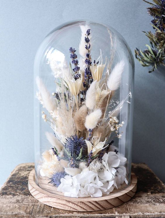 a cloche with lavender, thistles, white petals, bunny tail grasses and berries is a lovely boho home decor idea