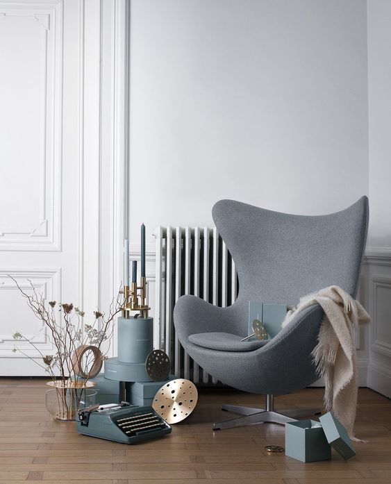 a cool Scandinavian space with a grey Egg chair, some vintage decor, boxes and candleholders is a very lovely nook