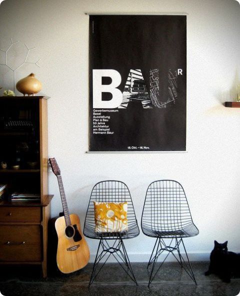 a cool modern space with a stained storage unit, black Eames wire chairs, some decor and artwork is a stylish nook