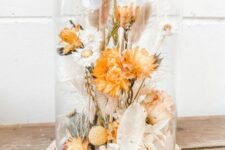 a dried flower dome with neutral and rust-colored dried blooms, leaves, seed pods is a cool decoration for homes