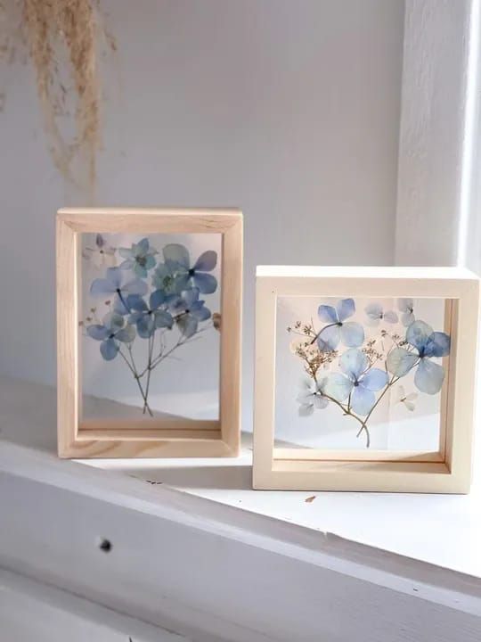 a duo of light-stained frames with blue pressed blooms is a cool decoration that will add a bit of color