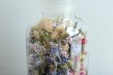 a glass bottle with moss and dried blooms and greenery is a creative decor idea for summer and not only, it’s a lovely rustic decoration