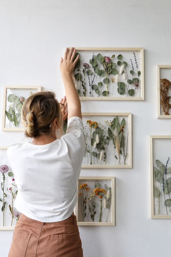 a gorgeous gallery wall with leaves, blooms and grasses in light stained frames is a chic and cool idea for any relaxed space