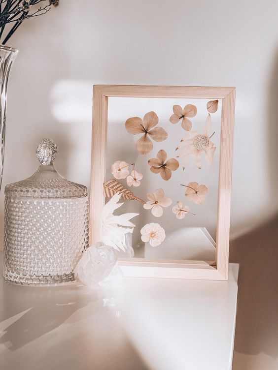 a light-stained frame with dried blooms and leaves is a beautiful home decoration for a boho or rustic space