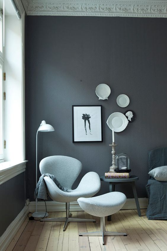 https://www.digsdigs.com/photos/2023/05/a-monochromatic-space-with-a-grey-accent-wall-a-black-sofa-and-a-pillow-a-black-side-table-a-light-blue-Swan-chair-and-a-footrest.jpg