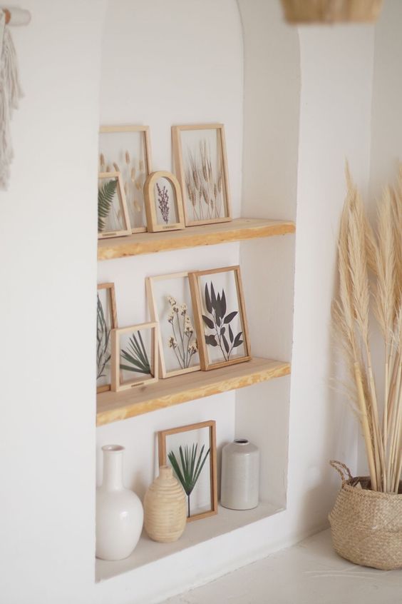 a niche with light-stained shelves, pressed leaves and grasses in light-stained frames is a beautiful decor solution