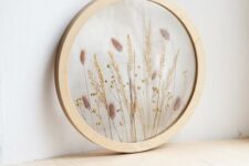 a round light-stained frame with dried grasses is a beautiful decoration for a boho or rustic space