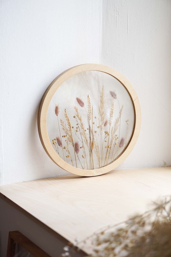 a round light stained frame with dried grasses is a beautiful decoration for a boho or rustic space