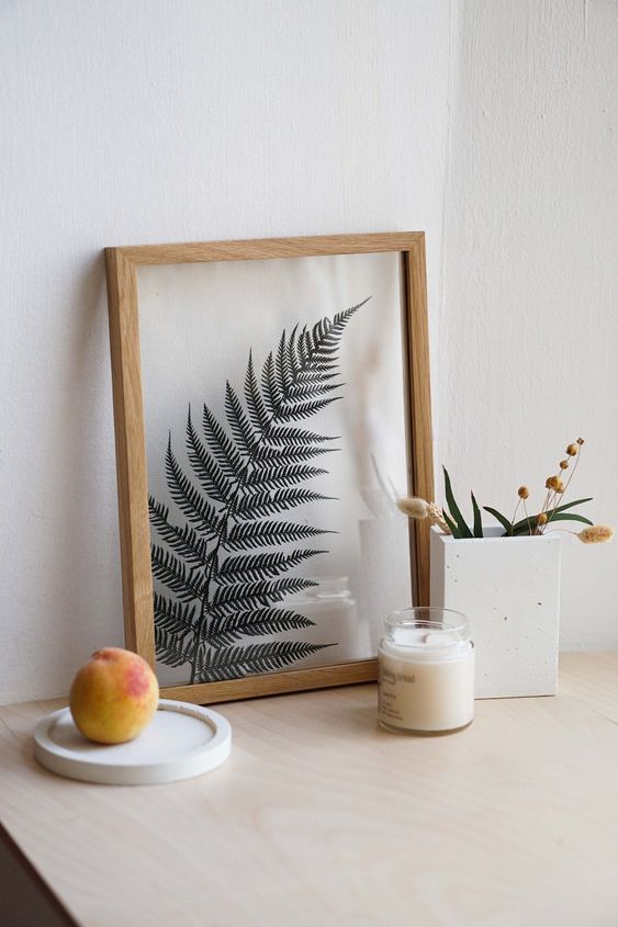a single fern leaf in a light stained frame is a beautiful and delicate artwork that is easy to DIY