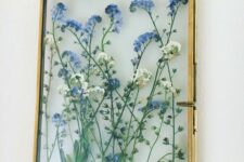 blue and white flowers in a gilded frame, with chain, are a chic and cool decoration for any space, they bring interest to it