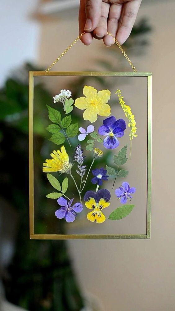 bold pansies and chamomiles plus leaves in a gilded frame with chain are amazing to style your space for summer