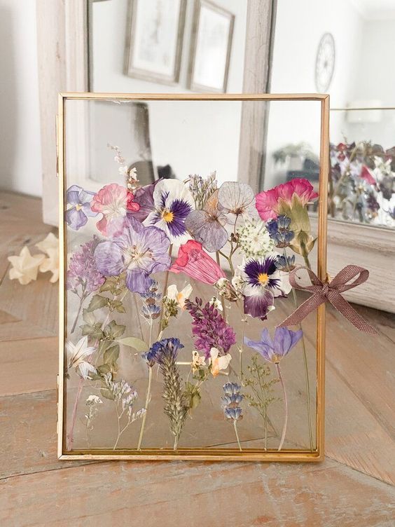 colorful blooms in a gilded frame, with leaves and a pretty purple bow are a cool decoration for any space, they look cool