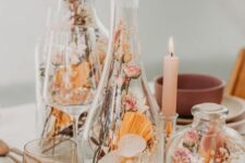 glass bottles of various designs filled with dried blooms, grasses and fronds are a cool arrangement for a rustic or boho space