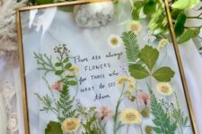 pressed yellow and pink blooms and leaves in a gold frame, with some words, are a cool botanical decoration for any space