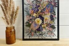 purple, pink and yellow pressed flowers plus leaves in a black frame are a cool decoration for any space with color