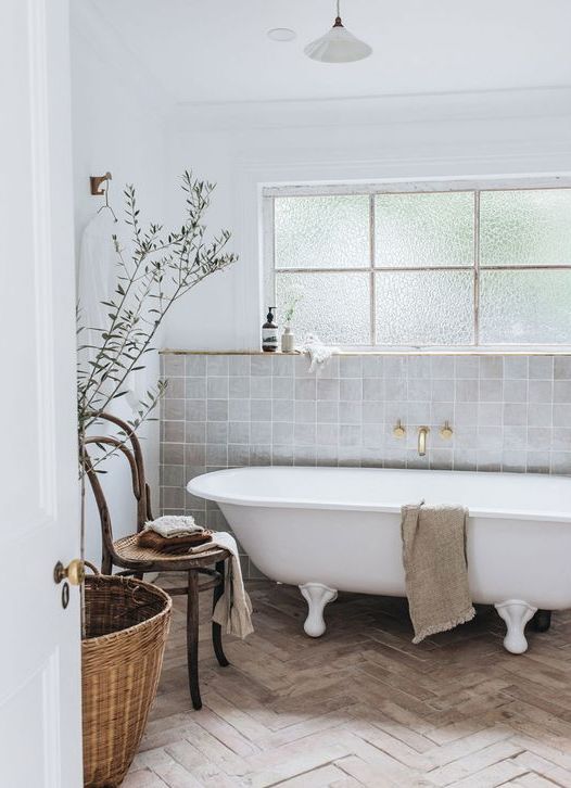 22-a-serene-neutral-bathroom-with-grey-Zellige-tiles-and-a-parquet-floor-a-clawfoot-tub-a-wooden-chair-a-basjet-and-some-delicate-decor.jpg
