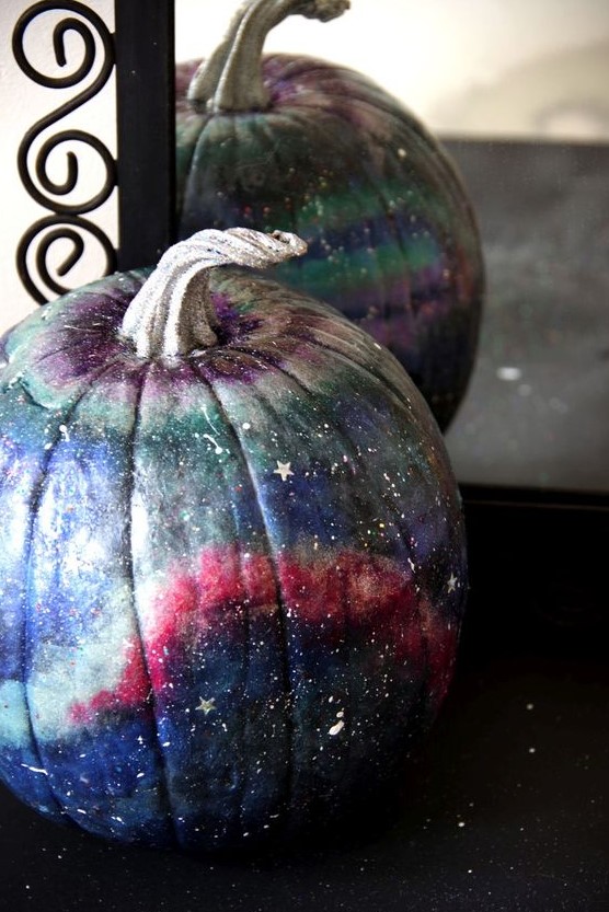a beautiful blue, pink, grey and purple galaxy pumpkin with little white and silver stars and constellations for Halloween