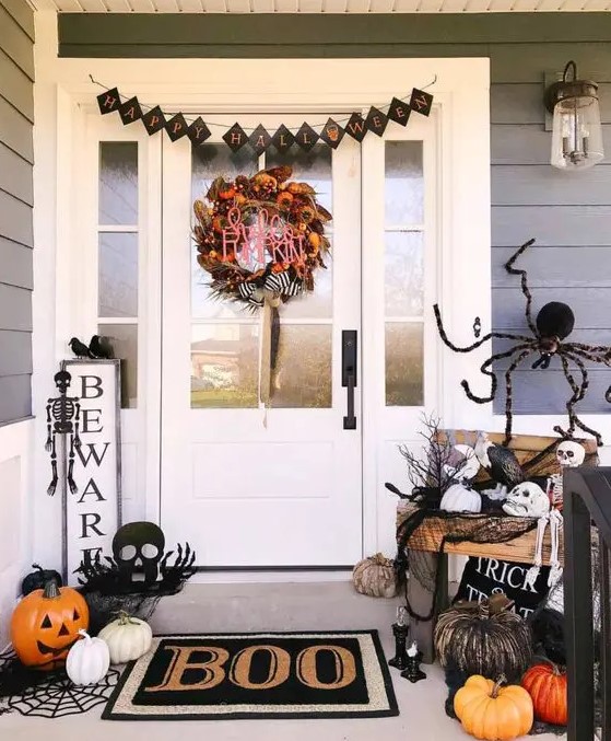 white, orange and black faux pumpkins, a spider, a black bunting, a black mat and spdierwebs, skulls and skeletons for Halloween
