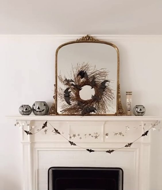 a chic vintage mirror in a gilded frame, with a twig wreath with black bats is a cool and easy to make decoration