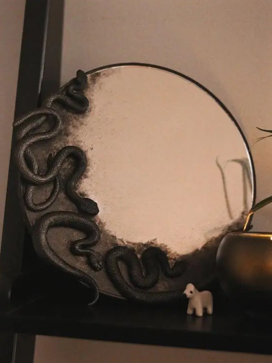 a round mirror with black snakes is a fast Halloween DIY that will look striking and spooky