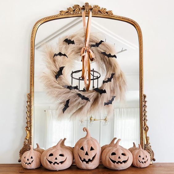 a mirror in a vintage frame, with a pampas grass wreath, a ribbon and black bats is a cool idea for Halloween