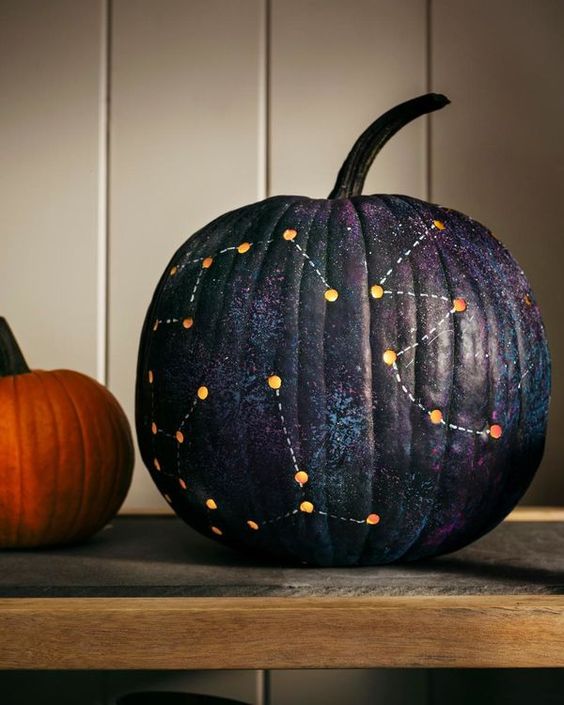 a dark galaxy pumpkin with constellations is a beautiful solution for Halloween styling