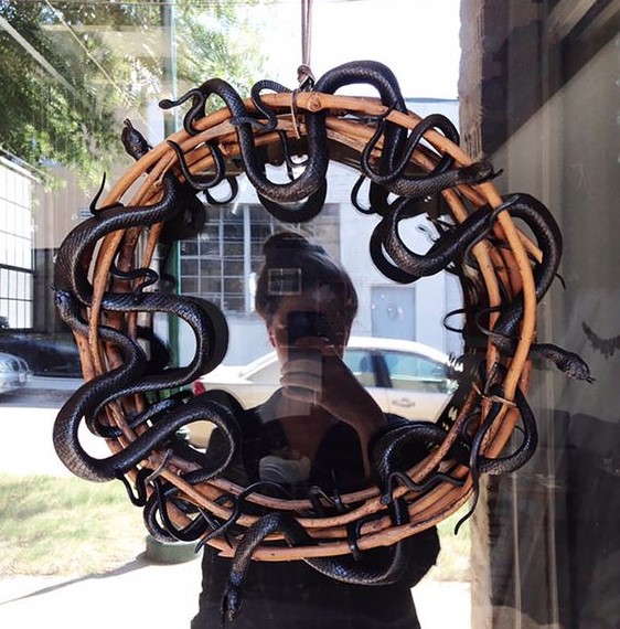 a branch wreath interwoven with black snakes is a simple and timeless idea for Halloween home decorating