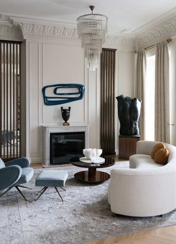 a refined living room with a curved white sofa and catchy decor and artworks that continue the unique style of the room