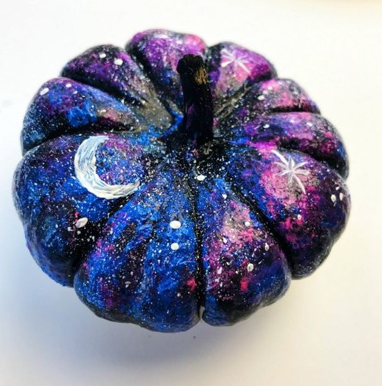 a small black, blue and hot pink pumpkin with white spot stars, large stars and moons for Halloween decor