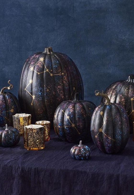 an arrangement of jaw-dropping black, purple and blue constellation pumpkins with gold constellations is fantastic
