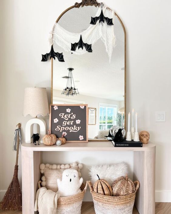 an arched mirror with cheesecloth and paper bats is a simple and cool solution for Halloween