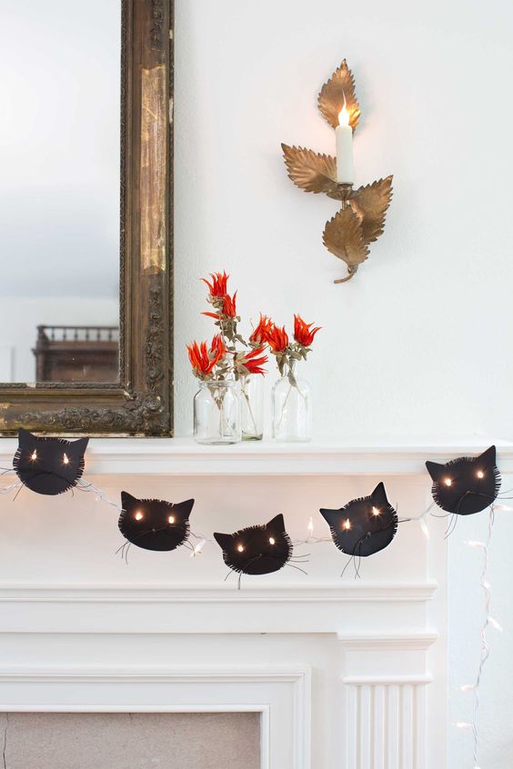 a black cat garland with lights is a stylish idea for Halloween, it looks cool and bold and isn't difficult to make