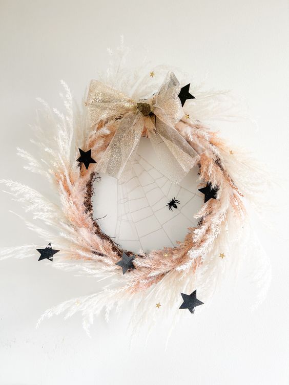 a beautiful celestial Halloween wreath with pampas grass, black stars, a spiderweb, a glitter bow is amazingg