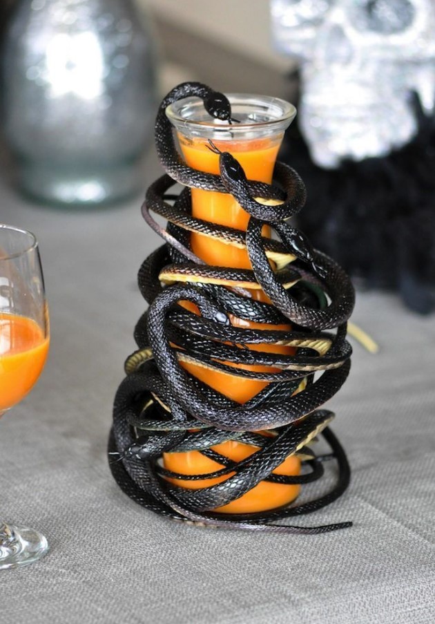 a jug with juice completely wrapped with black snakes is a stylish and scary solution for Halloween