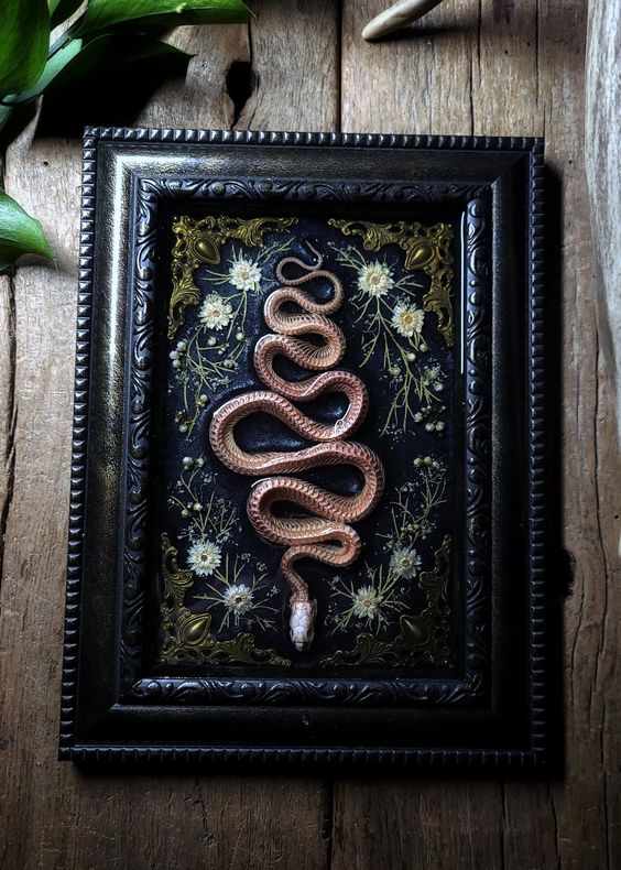 a beautiful Halloween artwork with dried blooms and a copper snake is a cool and chic idea for Gothic home decor